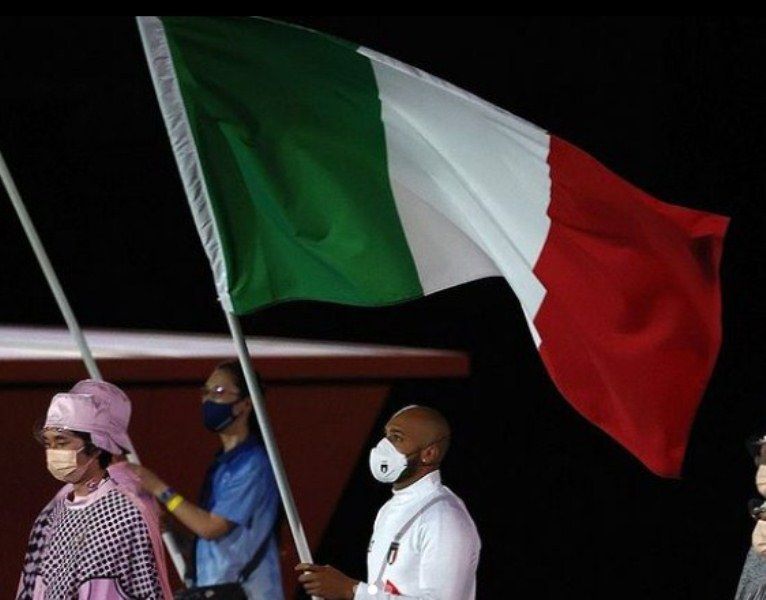 Lamont Marcell Jacobs bearing Italy's flag during the closing ceremony of 2020 Summer Olympics